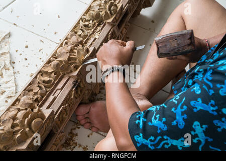 Die Hände eines Zimmermanns die traditionelle Holzschnitzerei in Bali, Indonesien. Lokale handwerkliche Tradition Konzept Stockfoto