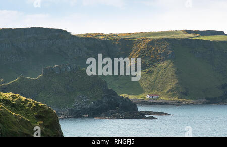 Ein Blick entlang der Küste von Antrim, Nordirland, zwischen Dunseverick Castle und Giant's Causeway, mit einem entfernten Scheune in der Ferne. Stockfoto