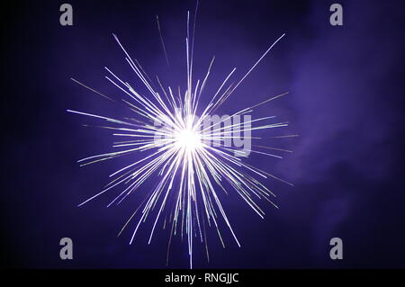Helle weisse Feuerwerk explodiert in den Nachthimmel. Stockfoto