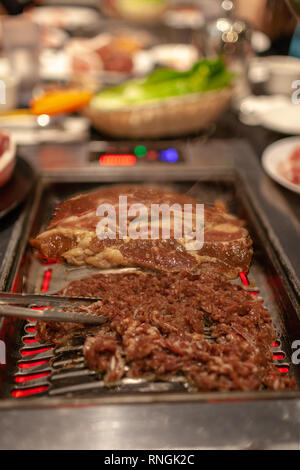 Koreanisches Barbecue mit saftigen Rindfleisch und Rippchen am heißen Herd platte Grill mit Smoke emitting vom Kochen. Stockfoto