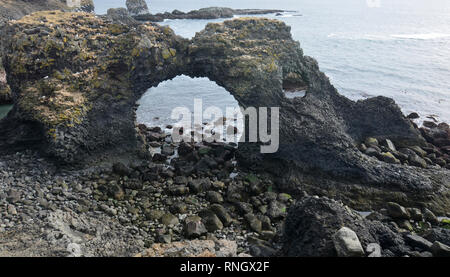 Schöne Küsten Arch Rock an der zerklüfteten Küste von Island. Stockfoto