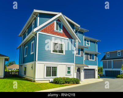 Fassade der Familie Haus mit grünen Rasen in Vorder- und Hintergrund des blauen Himmels Stockfoto