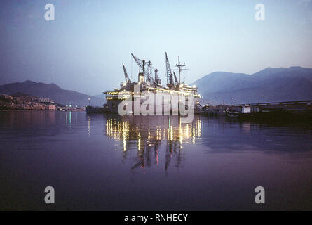 1982 - Steuerbord Quartal angesichts der Zerstörer USS Ausschreibung Puget Sound (AD-38), und 6. das Flaggschiff der Flotte, in seinen Heimathafen angedockt. Stockfoto