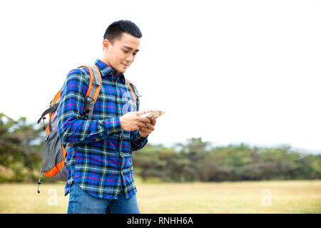 Junger Mann genießen Sie wandern Reise und sein Telefon surfen Stockfoto