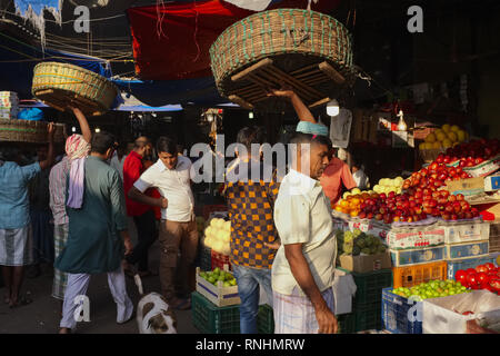 Ein Portier in Crawford Market (Mahatma Phule Jyotirao Markt), Mumbai, Indien, ein Großhandel Gemüse & Obst Markt, Salden seinen Korb über seinem Kopf Stockfoto