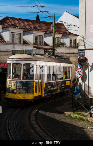 Lissabon, Portugal - 17. Februar 2018: Die 28 Straßenbahn Electrico (28) in einer engen Straße in der Alfama in der Nachbarschaft, in der Stadt Lissabon, Portugal Stockfoto