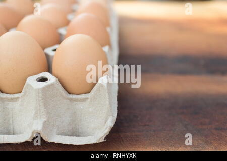 Braune Eier in Paket auf einem Holztisch, Bild mit kopieren. Stockfoto