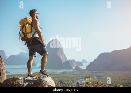 Wanderer steht auf einem Berg oder Viewpoint und betrachtet mit Blick auf Meer und Inseln. Travel Concept Stockfoto