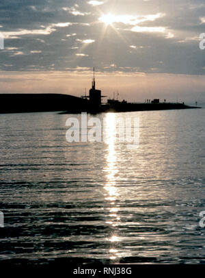 1982 - Ein port Bow View der nuklearen strategischen Raketen-U-Boots USS OHIO (SSBN-726) gegen die untergehende Sonne Silhouette mit Strom versorgt. Stockfoto