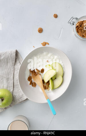 Gesundes Frühstück Multigrain Flakes mit Apple, griechischem Joghurt und hafermilch Draufsicht Stockfoto