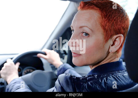 Das hübsche Mädchen hinter dem Lenkrad eines Autos. Erfolgreiche Geschäftsfrau rund um die Stadt reist. Stockfoto