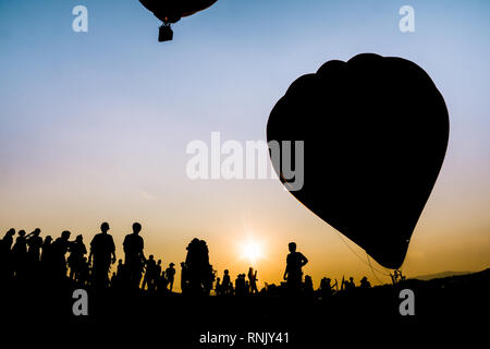 Silhouette Menschen im Ballon Festival am schönen Sonnenuntergang Himmel bei Singha Park, Chiang Rai, Thailand Stockfoto