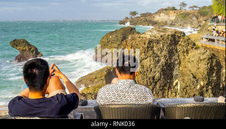 Zwei Chines männliche Touristen in der Rock Bar am Ayana Resort & Spa Jimbaran Bali Indonesien. Stockfoto