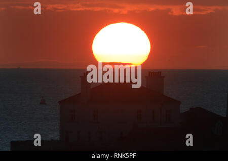 Die Sonne über einem Haus in St Mary's Island in Whitley Bay, North Tyneside. Stockfoto