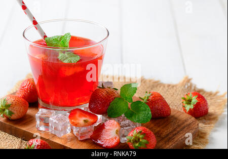 Erdbeersaft und Pfefferminze oben und frische Erdbeeren auf Holz Block, Sommer Getränke Konzept Stockfoto