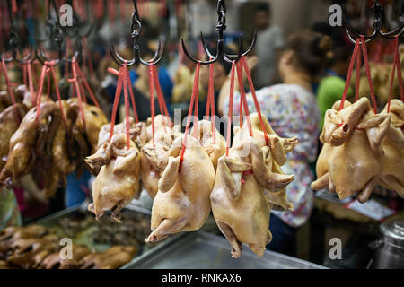 Menge Huhn stellen Hängen auf dem roten Seilen auf dem schwarzen Haken in den chrome Fächer auf den unscharfen Hintergrund der Street Market in Bangkok Stockfoto