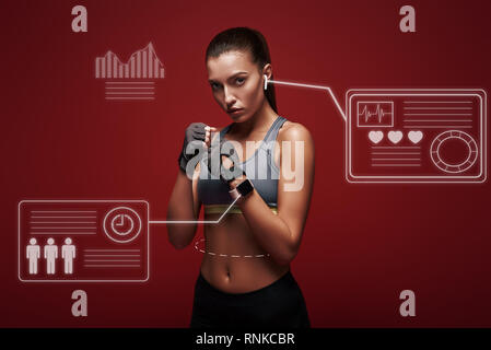 Schöne Sportlerin workout Handschuhe zu tragen bereit ist. Über den roten Hintergrund isoliert Stockfoto