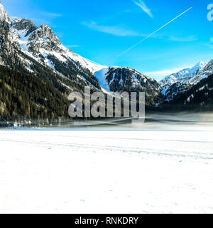 Schöne Berglandschaft mit früh Morgens Nebel auf Antholz - Antholzer Siehe zugefrorenen See, im Pustertal, Südtirol, Südtirol, Alpen in Stockfoto