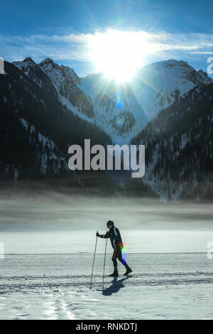 Antholzer See, Pustertal, Südtirol, Italien - 16. Februar 2019: eine Frau Himmel am Antholzer See als am frühen Morgen Sonne erscheinen Stockfoto