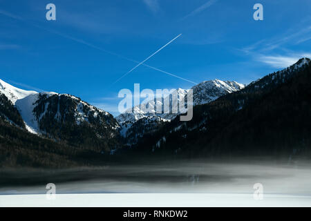 Schöne Berglandschaft mit früh Morgens Nebel auf Antholz - Antholzer Siehe zugefrorenen See, im Pustertal, Südtirol, Südtirol, Alpen in Stockfoto