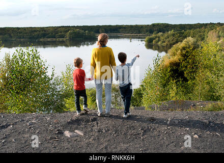 Frau, Mutter mit ihren beiden Kindern, zwei Hände halten, mit Blick auf den See "Lac de la Mare' in Goriaux, im Wald von Raismes-Saint Amand Wallers, Steilhang Stockfoto