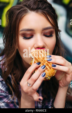 Foodie mit Hamburger beiseite, mit entsetzten Ausdruck. Stockfoto