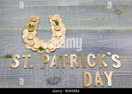 Symbol für Glück Hufeisen, gesäumt mit britischen Goldmünzen, Klee, Inschrift in goldenen Buchstaben - St. Patricks Tag Stockfoto