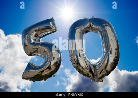 Silber Ballons für einen 50-jährigen Floating unter den Wolken Stockfoto