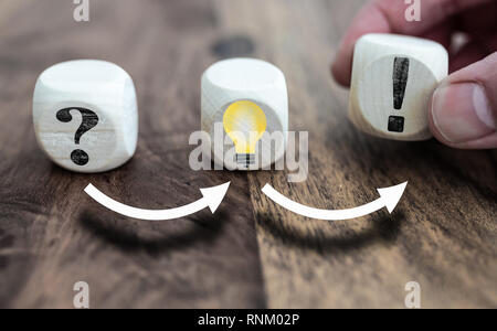Lösen von Problemen mit Fragezeichen, Glühbirne symbolisiert eine Idee und Ausrufezeichen auf Holzklötze Stockfoto
