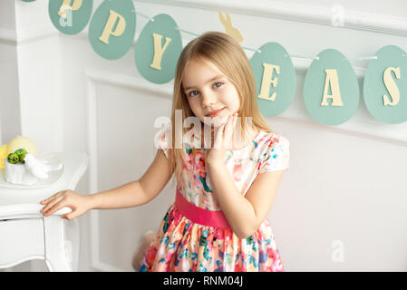 Attraktive Mädchen in bunten Kleid posiert und lächelnd vor dem Hintergrund einer dekorierten Tisch Stockfoto