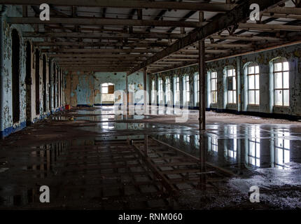 Licht aus den Fenstern der alten Mühle in der wassergesättigten Boden wider Stockfoto