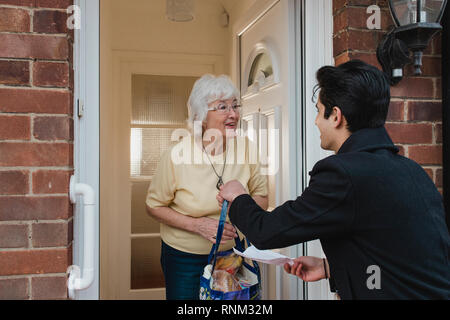 Teenager liefert Lebensmittel zu seiner Großmutter. Stockfoto