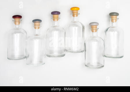 Kleine Glasflaschen mit der farbigen Kappe nach oben auf eine weiße Fläche gezeichnet Stockfoto