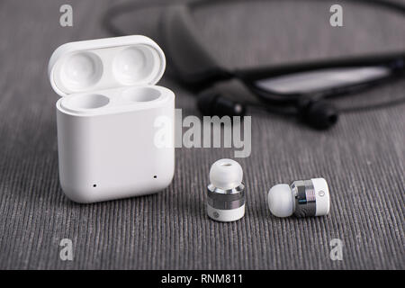 Wireless Bluetooth Ohrhörer mit aufladbaren Fall auf einem Hintergrund von Hals band Typ Ohrhörer Stockfoto