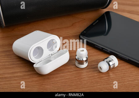 Wireless Bluetooth Ohrhörer und kostenpflichtigen Fall mit Smartphone und partable Lautsprecher Stockfoto