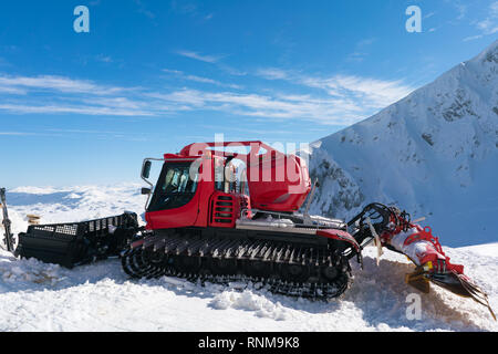 Pistenraupe auf einem schneebedeckten Hang in einem Skigebiet Stockfoto