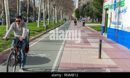 Murcia, Spanien, 18. Februar 2019: Mann fährt mit dem Fahrrad über Bike Linie entlang einer Straße in Murcia. Stockfoto