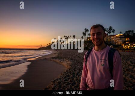 Junger Mann am Strand bei Sonnenuntergang, Laguna Beach, Orange County, Kalifornien, USA Stockfoto