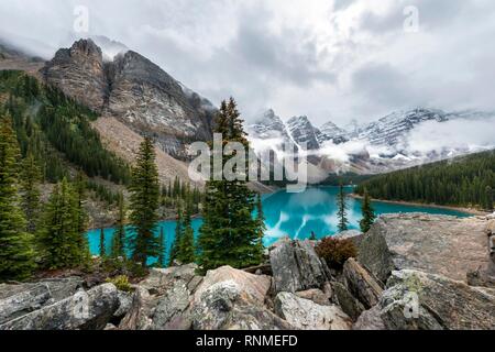 Wolken zwischen den Berggipfeln, Reflexion in türkisfarbenen Gletscherseen, Moraine Lake, Tal der zehn Gipfel, Rocky Mountains, Banff Nationa
