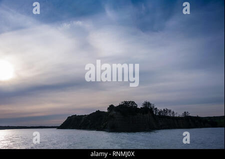 Moody Sonnenuntergang im Hauraki Gulf, Waiheke nach Auckland. Atemberaubende Landschaft, landspitze gegen die untergehende Sonne. Stockfoto