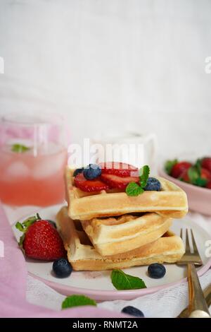 Stapel von hausgemachten flauschige Waffeln mit Beeren Sirup und pink Limonade auf warmen weissen Hintergrund/Valentines Tag Frühstück, selektiven Fokus Stockfoto