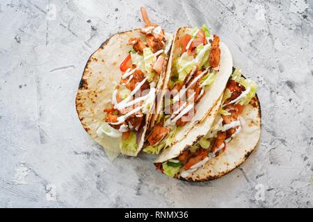 Hausgemachte gegrillter Lachs Fisch Tacos beträufelt mit Sauerrahm Stockfoto