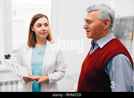 Älterer Mann berät mit seinem Arzt in der Klinik Stockfoto