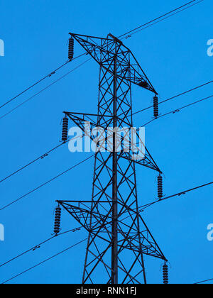 Hohe Metall pylon Unterstützung für Power Linien mit einem klaren blauen Himmel Hintergrund Stockfoto