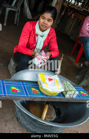 Kambodschanische Frau, die kocht, sammelte in einem kleinen Dorf in Siem Reap, Kambodscha, saft, um Palmzuckerbonbons herzustellen. Stockfoto