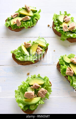 Thunfisch Sandwiches mit Avocado und Salatblätter. Lecker Thunfisch Brötchen zum Frühstück oder Mittagessen. Gesunden Snack. Stockfoto