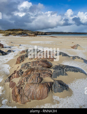 Lewisian Gneis Felsbrocken auf Uige Strand, Insel Lewis, Äußere Hebriden, Schottland. Nach einem Hagel Dusche. Stockfoto