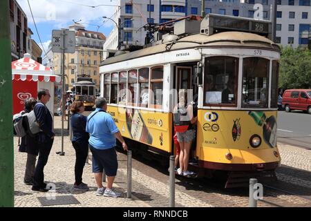 Lissabon, Portugal - Juni 5, 2018: die Menschen fahren Sie mit dem gelben Straßenbahn in Praça Martim Moniz in Lissabon, Portugal. Der Lissaboner Straßenbahn geht zurück auf 187 Stockfoto