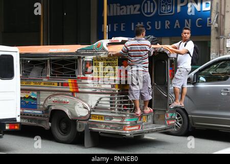 MANILA, Philippinen - November 25, 2017: Die Menschen fahren mit dem Jeepney öffentliche Verkehrsmittel in dichtem Verkehr in Manila, Philippinen. Metro Manila ist eines der t Stockfoto