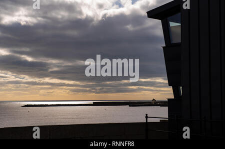 Die moderne Fassade von Lyme Regis Museum (Das Philpot Museum) in Lyme Regis sillhouted gegen einen Himmel mit dem Cobb in der Ferne. Stockfoto